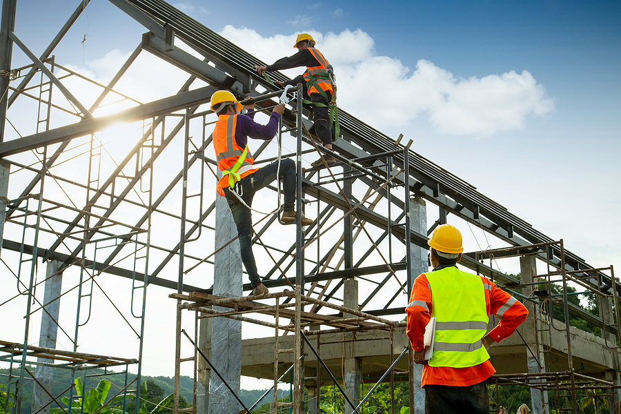 Asian construction worker control in the construction of roof structures and worker wear safety height equipment to install the roof. Fall arrestor device for worker with hooks for safety body harness, Worker as in the construction site